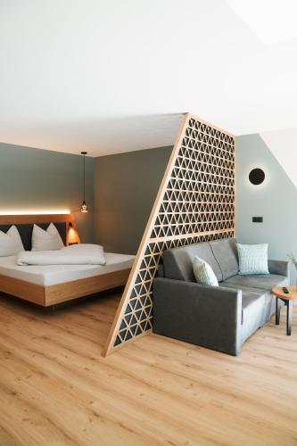 a living room with a couch and a bed at Aktiv Lodge Meran - Garden One in San Martino