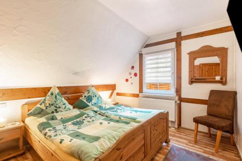 a bedroom with a bed and a chair and a window at Ferienhaus 'am Aartalsee' in Ahrdt