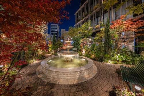 a fountain in the middle of a city at night at Hotel Trad Hakata in Fukuoka