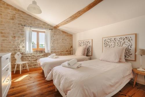 two beds in a room with white sheets at La Belle Parenthèse à la Rochelle in Vergné