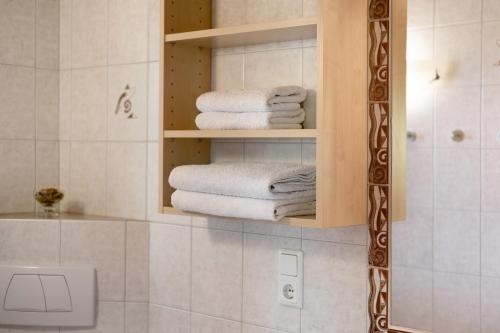 a bathroom with white towels in a cabinet at New Teindlhof in Curon Venosta