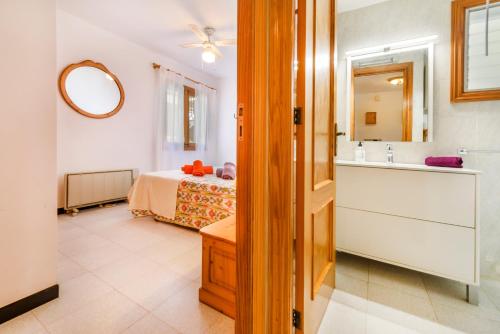 a bathroom with a bed and a sink and a mirror at Puerto Rico Apt. Port de Sóller in Port de Soller