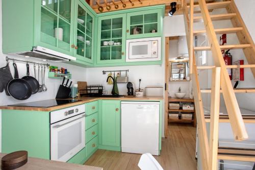 a kitchen with green cabinets and a ladder at Casa Valada My Land in Valada