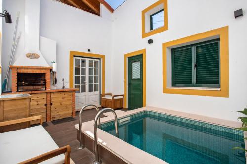a swimming pool in a house with a kitchen and a fireplace at Casa Valada My Land in Valada