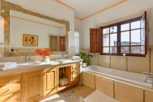 a bathroom with a tub and a large mirror at Finca Remedios in Los Valles