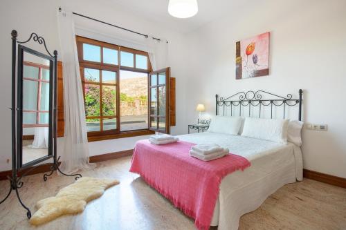 a bedroom with a large bed with a pink blanket at Finca Remedios in Los Valles
