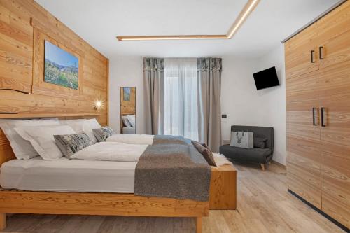 a bedroom with a large bed and a chair at La Douce Pomme in Saint-Pierre