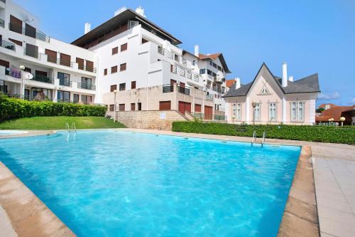 a large swimming pool in front of a building at Apartamento Vista Baia in São Martinho do Porto