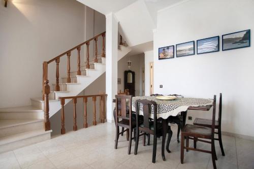 a dining room with a table and chairs and stairs at Apartamento Vista Baia in São Martinho do Porto