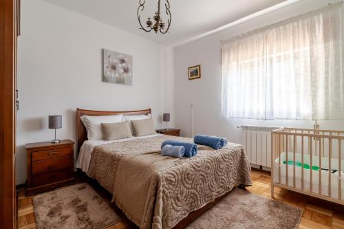 a bedroom with a bed with two blue pillows on it at Casa Mourelo Alojamento Local in Ponte da Barca