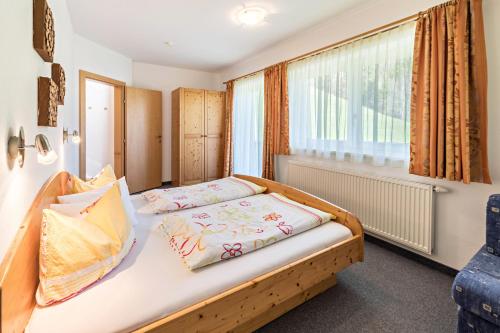a bedroom with a bed and a window at Ferienwohnung Jakob in Schwendau