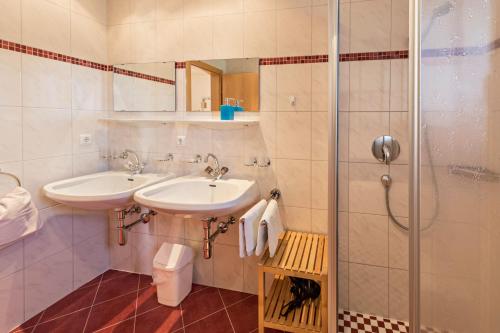 a bathroom with two sinks and a shower at Ferienwohnung Jakob in Schwendau