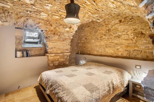 a bedroom with a bed and a stone wall at Modern Heritage House in Imperia