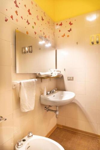a bathroom with a sink and a mirror with butterflies on the wall at Nice Lake view apartment in Ispra