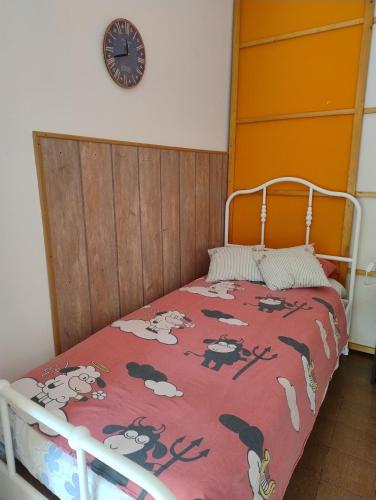 a bedroom with a bed and a clock on the wall at Nice Lake view apartment in Ispra