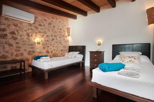 a bedroom with two beds and a wooden floor at Son Soler - Can Torres in Islas Baleares