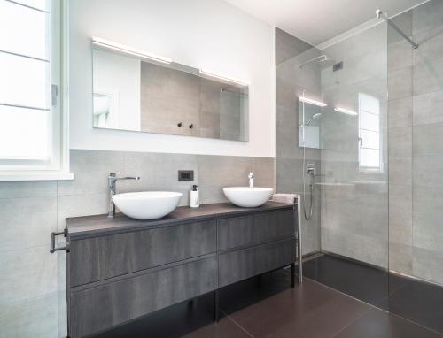 a bathroom with two sinks on a counter with a shower at Villa Angelina in Lazise