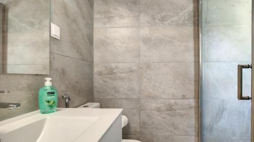 a bathroom with a sink and a toilet and a mirror at Villa Palmeira Galé Beach in Albufeira