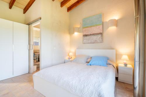 a bedroom with a white bed with two blue pillows at Redonda 1 in Costitx