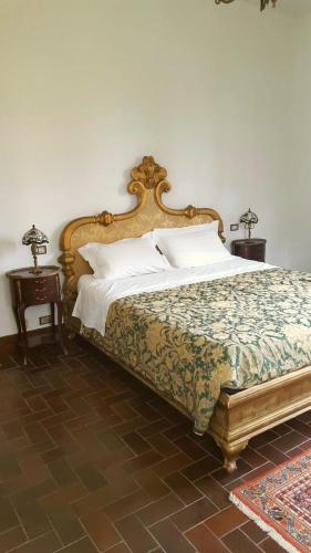 a bedroom with a large bed with a wooden headboard at Villa Giacinti in Padova
