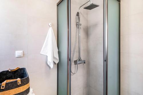 a shower with a glass door in a bathroom at Oceanida Thalia Lyxury Suite in Nikiana