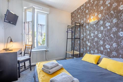 a bedroom with a bed and a desk and a television at Chambres Espace Rennaissance in Chantonnay