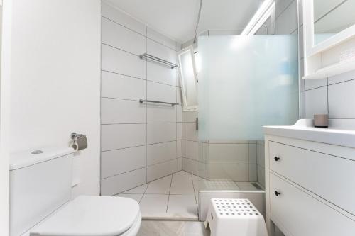 a white bathroom with a toilet and a shower at Casa Feliz in Mijas