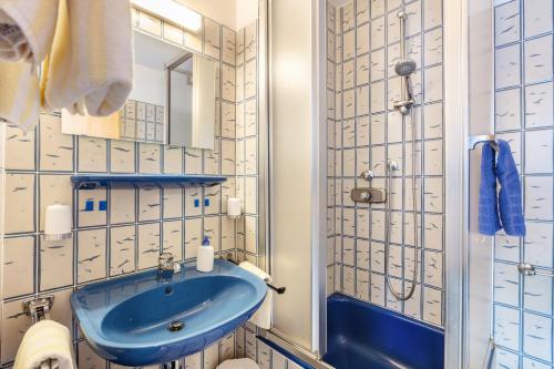a bathroom with a blue sink and a shower at Pension Alte Gerbe in Außerurberg