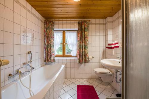 a bathroom with a tub and a toilet and a sink at Ferienhaus Annelies in Übersee