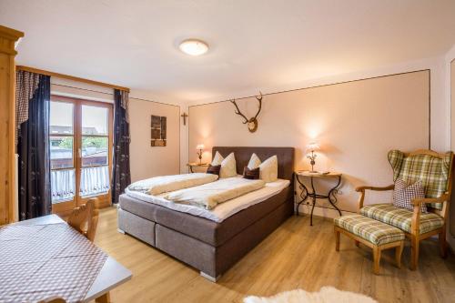 a bedroom with a bed and a chair at Ferienhaus Annelies in Übersee