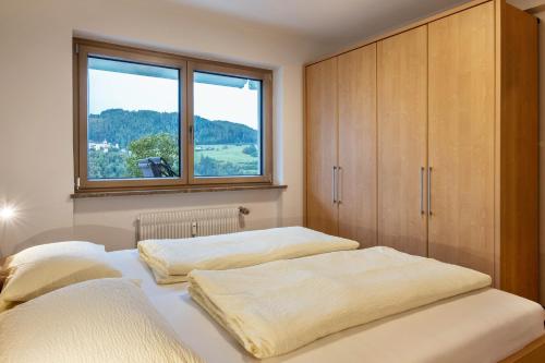 two beds in a bedroom with a window at Appartement Schlern Living 1 in Völs am Schlern