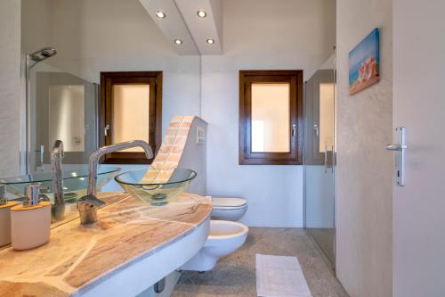 a bathroom with a sink and a toilet at Villa Sirius - sea view - wellness in Costa Paradiso