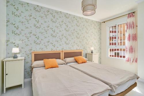 a bedroom with a large bed with orange pillows at Primera línea con terraza A104 in Torrox