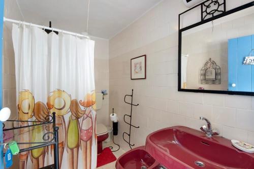 a bathroom with a red sink and a mirror at Casa dos Afectos - Costa Nova in Gafanha da Encarnação