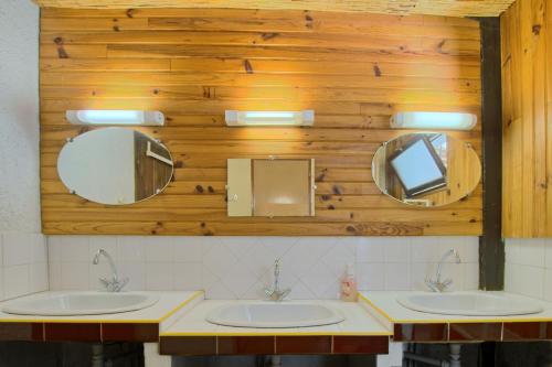 two sinks in a bathroom with two mirrors at Maison Skioura, Gite De Groupe in Luchon