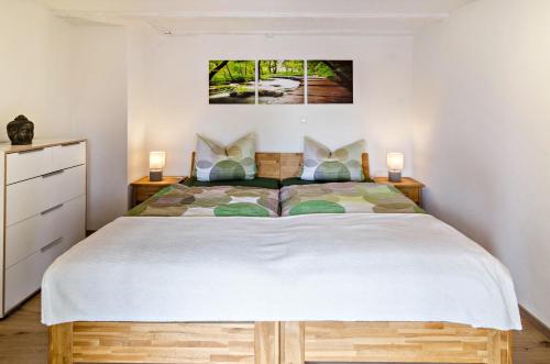 a bedroom with a large bed with two lamps at Ferienwohnung Kunstmann in Überlingen