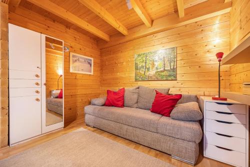 a living room with a couch in a room with wooden walls at Hütte im Heidekreis in Lindwedel