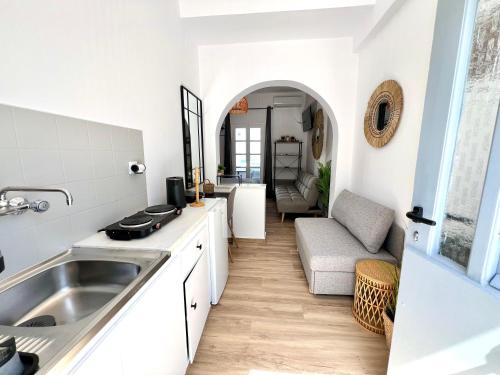 a kitchen with a sink and a living room at aeolian blu 6 in Parikia