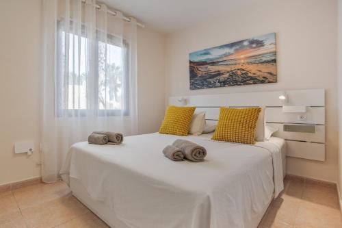 a bedroom with a large white bed with two pillows on it at Oasis Duna_ Casa Elena Pool in Corralejo