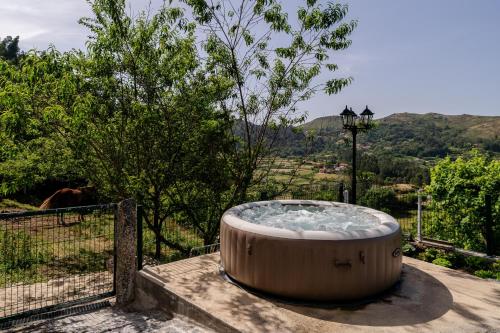 a large hot tub sitting on the side of a building at Casa Mourelo Alojamento Local in Ponte da Barca