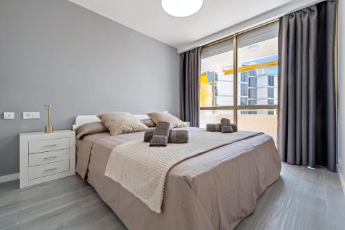 a bedroom with two beds and a large window at Calafenga in Calafell