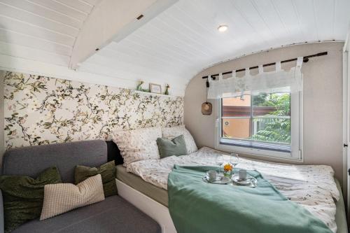 a caravan bedroom with a bed and a table at Amselnest in Dobeneck