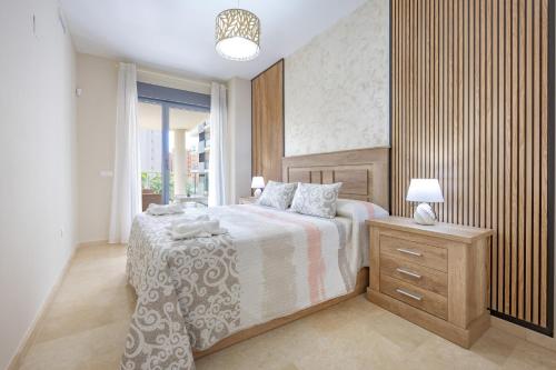 a bedroom with a bed and a nightstand and a window at Cala alta in Benidorm