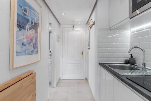 a white kitchen with a sink and a white door at Miraflores A112 in La Cala de Mijas