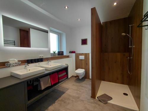 ein Badezimmer mit zwei Waschbecken, Dusche und Toilette in der Unterkunft Hümmer Chalets in Breitengüßbach