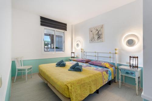 a bedroom with a bed and a table and a window at Relax Holidays Corralejo in Corralejo