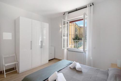 a white bedroom with a bed and a window at Moneglia Monte in Moneglia
