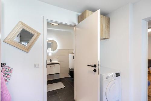 a small white bathroom with a washer and dryer at Pr-Ferienwohnung in Stierstadt