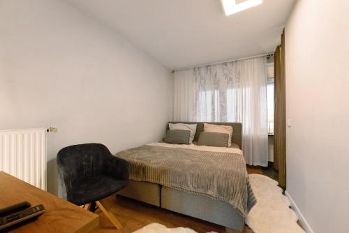 a bedroom with a bed and a chair and a window at Gemütliche Wohnung in Reimsbach in Beckingen