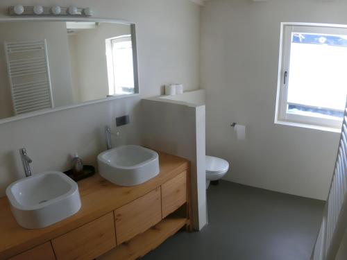 a white bathroom with a sink and a mirror at Chalet Finkennest in Neukirchen am Großvenediger